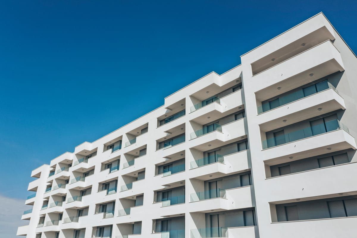 Glass railings on the balconies of a white apartment building